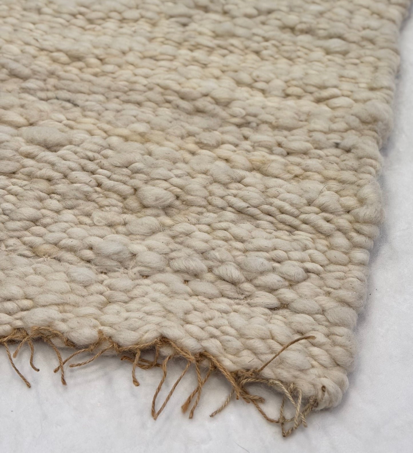 This beautiful hand woven, off white, sheep wool rug is made from 100% sheep wool grown right here at Wild Daisy Homestead.
The warp and trim are made with 100% natural jute string. Created on a peg loom this 23X26 rug is tightly woven together. When removed, the finishing touches by tying the trim and hand stitching of the 100% leather tag attached, complete the project.