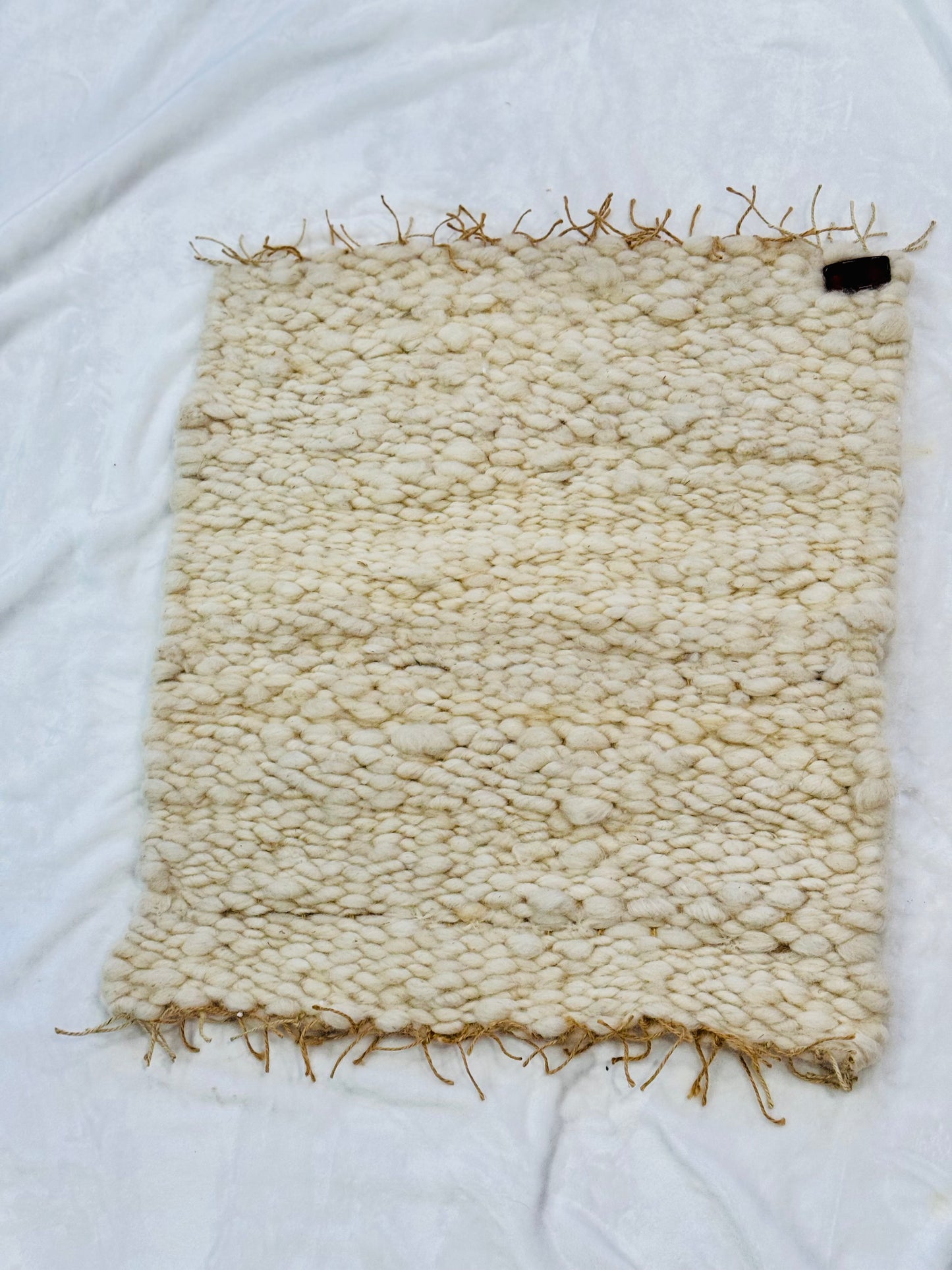 This beautiful hand woven, off white, sheep wool rug is made from 100% sheep wool grown right here at Wild Daisy Homestead.
The warp and trim are made with 100% natural jute string. Created on a peg loom this 23X26 rug is tightly woven together. When removed, the finishing touches by tying the trim and hand stitching of the 100% leather tag attached, complete the project.