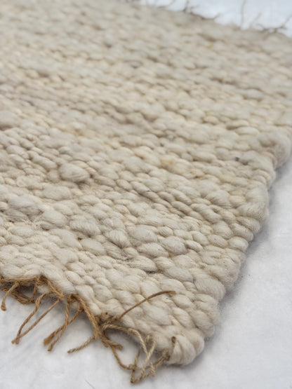 This beautiful hand woven, off white, sheep wool rug is made from 100% sheep wool grown right here at Wild Daisy Homestead.   
The warp and trim are made with 100% natural jute string.  Created on a peg loom this 23X26 rug is tightly woven together. When removed,  the finishing touches by tying the trim and hand stitching of the 100% leather tag attached, complete the project.  