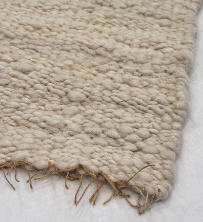 This beautiful hand woven, off white, sheep wool rug is made from 100% sheep wool grown right here at Wild Daisy Homestead.   
The warp and trim are made with 100% natural jute string.  Created on a peg loom this 23X26 rug is tightly woven together. When removed,  the finishing touches by tying the trim and hand stitching of the 100% leather tag attached, complete the project.  