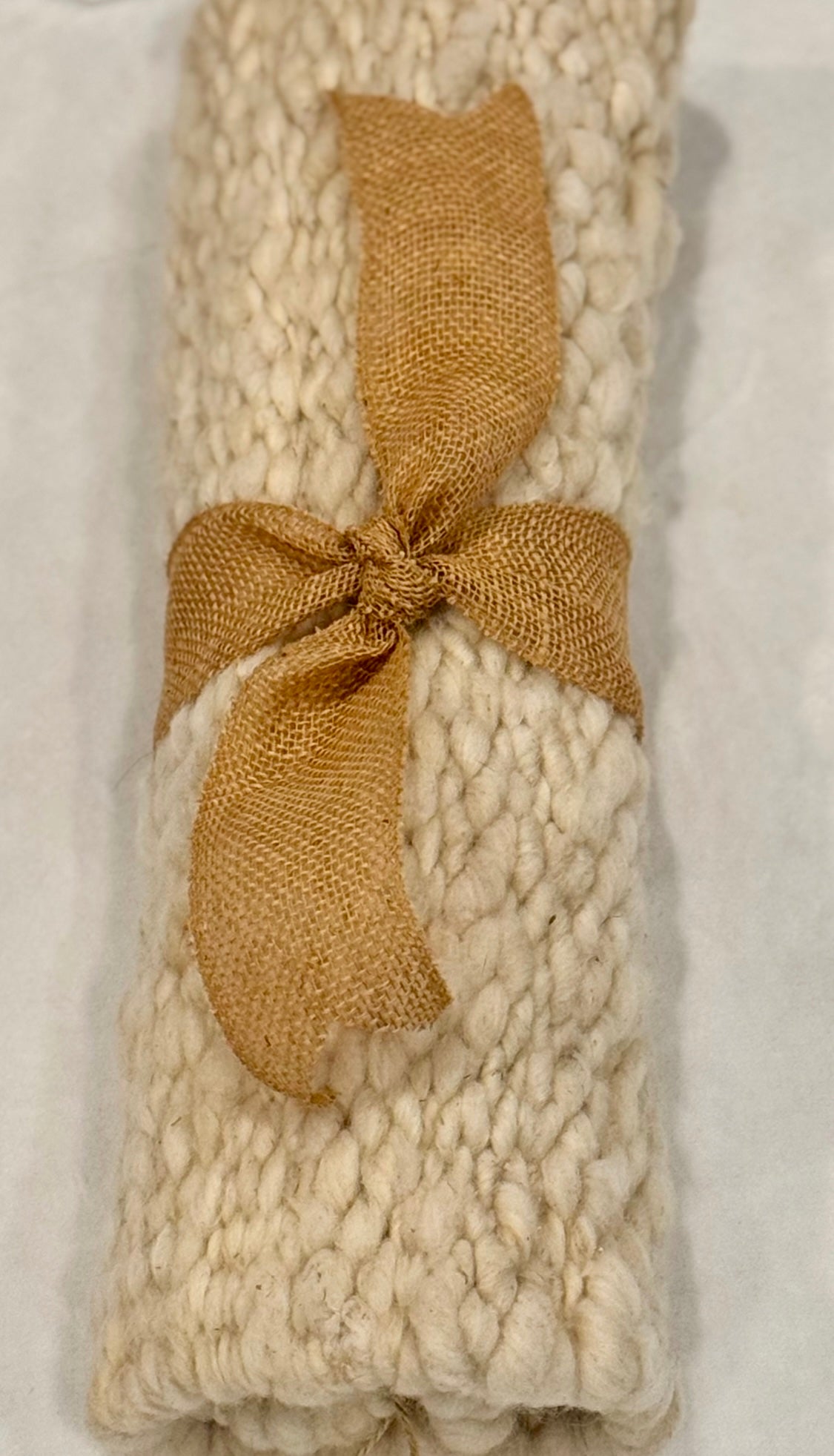 This beautiful hand woven, off white, sheep wool rug is made from 100% sheep wool grown right here at Wild Daisy Homestead.   
The warp and trim are made with 100% natural jute string.  Created on a peg loom this 23X26 rug is tightly woven together. When removed,  the finishing touches by tying the trim and hand stitching of the 100% leather tag attached, complete the project.  