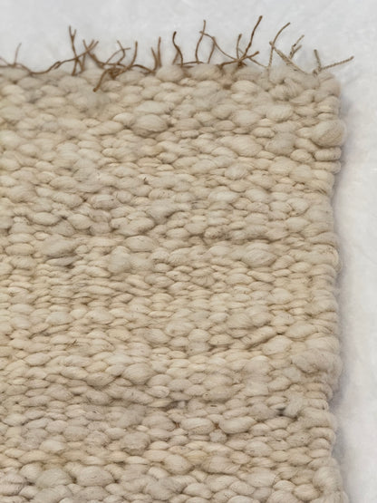 This beautiful hand woven, off white, sheep wool rug is made from 100% sheep wool grown right here at Wild Daisy Homestead.   
The warp and trim are made with 100% natural jute string.  Created on a peg loom this 23X26 rug is tightly woven together. When removed,  the finishing touches by tying the trim and hand stitching of the 100% leather tag attached, complete the project.  